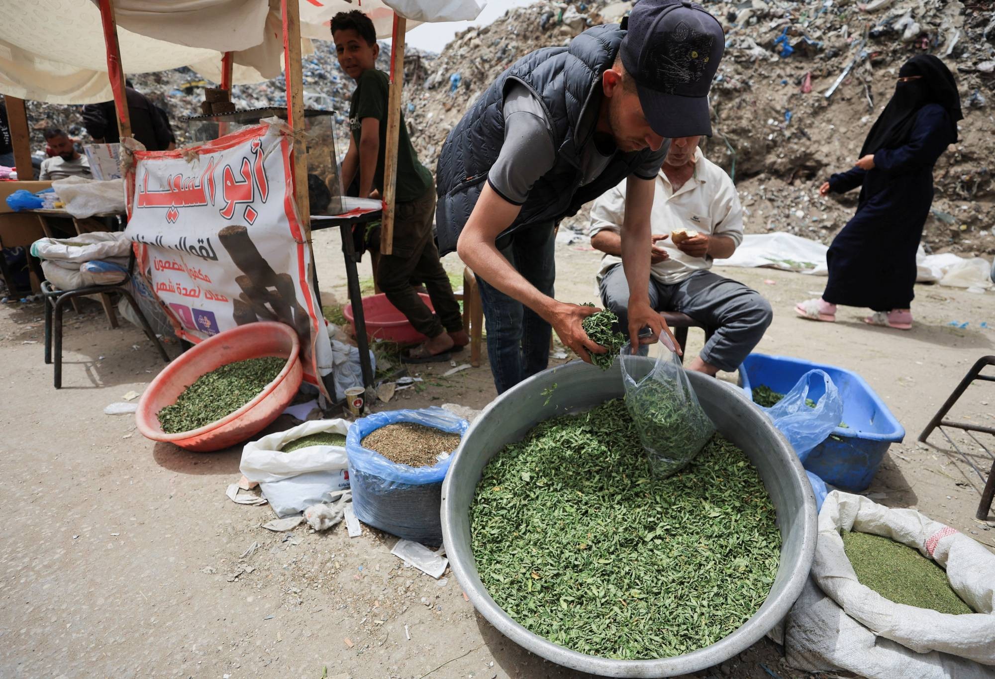 بائعون فلسطينيون يبيعون السجائر المصنوعة من الملوخية (رويترز).jpeg