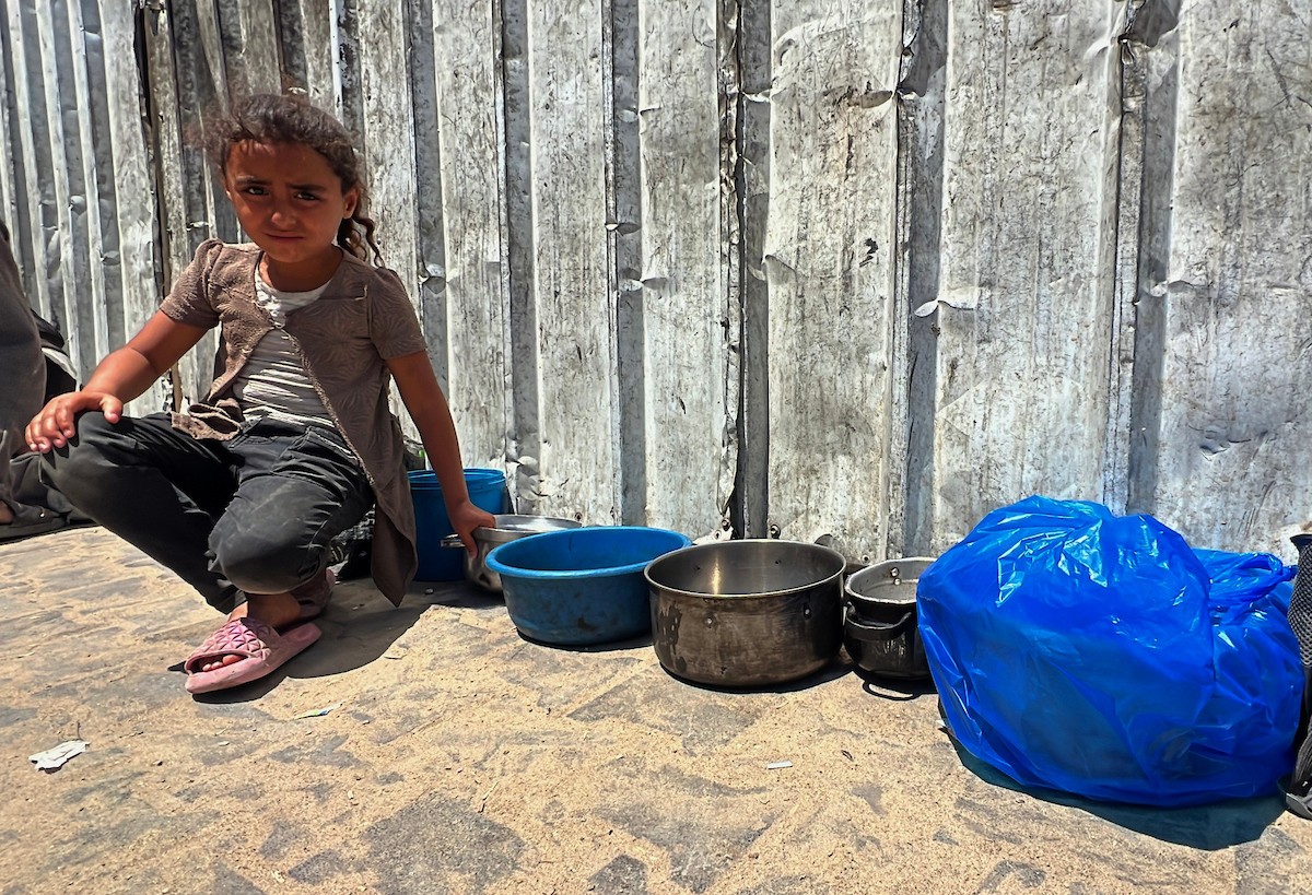 يتلقى فلسطينيون نازحون طعامًا من مطبخ خيري في مخيم النصيرات للاجئين وسط قطاع غزة، في 23 أبريل/نيسان 2026، (صورة: يوسف أبو وطفة)