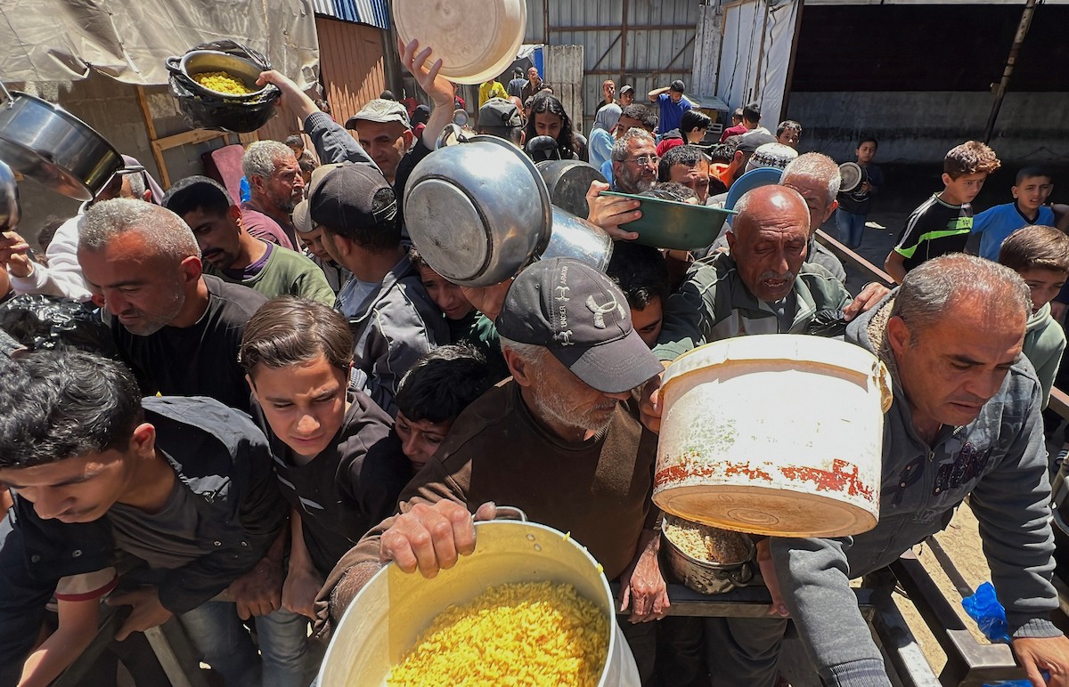 يتلقى فلسطينيون نازحون طعامًا من مطبخ خيري في مخيم النصيرات للاجئين وسط قطاع غزة، في 23 أبريل/نيسان 2026، (صورة: يوسف أبو وطفة)