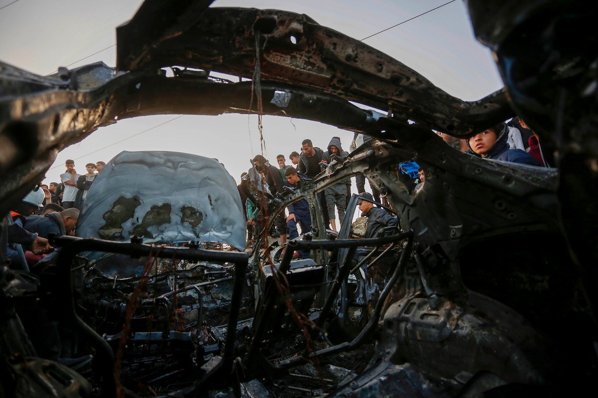 يتفقد فلسطينيون آثار غارة جوية إسرائيلية استهدفت مركبة في شارع صلاح الدين قرب مدخل مخيم المغازي للاجئين وسط قطاع غزة، في 4 أبريل/نيسان 2026.  (صورة: أحمد إبراهيم)