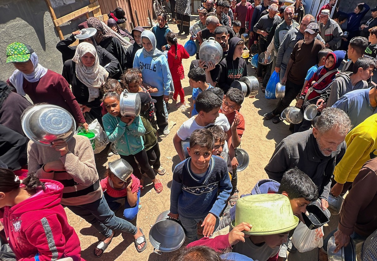 يتلقى فلسطينيون نازحون طعامًا من مطبخ خيري في مخيم النصيرات للاجئين وسط قطاع غزة، في 23 أبريل/نيسان 2026، (صورة: يوسف أبو وطفة)