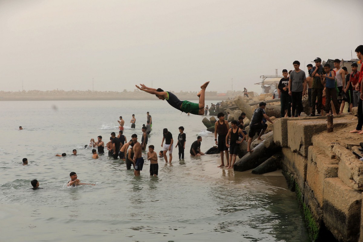 يقضي أطفال فلسطينيون أوقاتهم على شاطئ  غزة، باحثين عن ملاذ من حرارة الشمس وضغوط الحياة اليومية، في ظلّ الظروف الإنسانية المتردية التي يواجهها سكان القطاع جراء الحرب الدائرة، 17 أبريل/نيسان 2026. تصوير: بلال أسامة