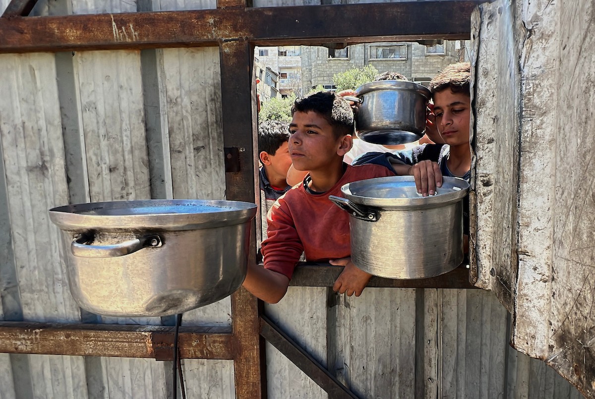 يتلقى فلسطينيون نازحون طعامًا من مطبخ خيري في مخيم النصيرات للاجئين وسط قطاع غزة، في 23 أبريل/نيسان 2026، (صورة: يوسف أبو وطفة)