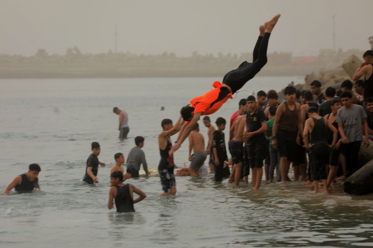يقضي أطفال فلسطينيون أوقاتهم على شاطئ  غزة، باحثين عن ملاذ من حرارة الشمس وضغوط الحياة اليومية، في ظلّ الظروف الإنسانية المتردية التي يواجهها سكان القطاع جراء الحرب الدائرة، 17 أبريل/نيسان 2026. تصوير: بلال أسامة