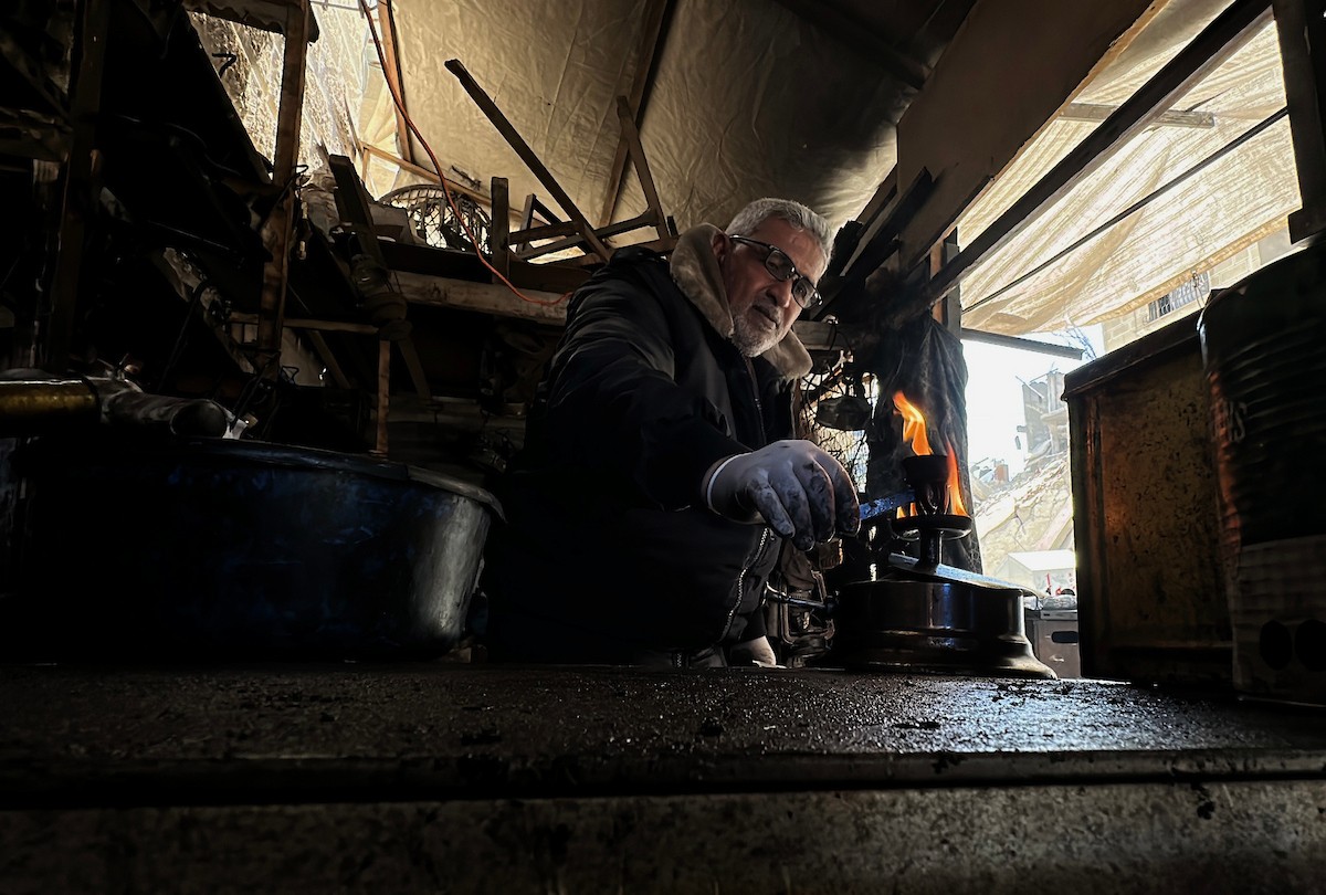 عادل عيسى، 63 عامًا، يُصلح مواقد الكيروسين القديمة في ورشته بمخيم الشاطئ، في مدينة غزة، صورة فوتوغرافية لهادي داود
