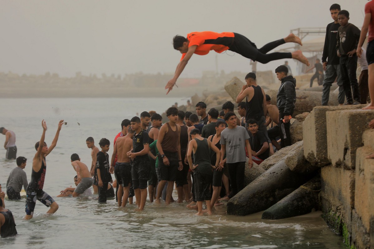 يقضي أطفال فلسطينيون أوقاتهم على شاطئ  غزة، باحثين عن ملاذ من حرارة الشمس وضغوط الحياة اليومية، في ظلّ الظروف الإنسانية المتردية التي يواجهها سكان القطاع جراء الحرب الدائرة، 17 أبريل/نيسان 2026. تصوير: بلال أسامة