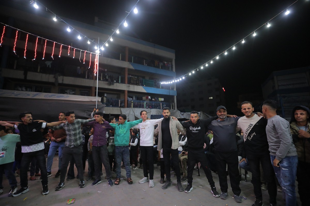 فلسطينيون نازحون يشاركون في حفل زفاف الشاب ماهر حمدية داخل مدرسة حُوّلت إلى مأوى في مخيم النصيرات، وسط قطاع غزة، 26 أبريل/نيسان 2026. (تصوير: حسن الجديدي)