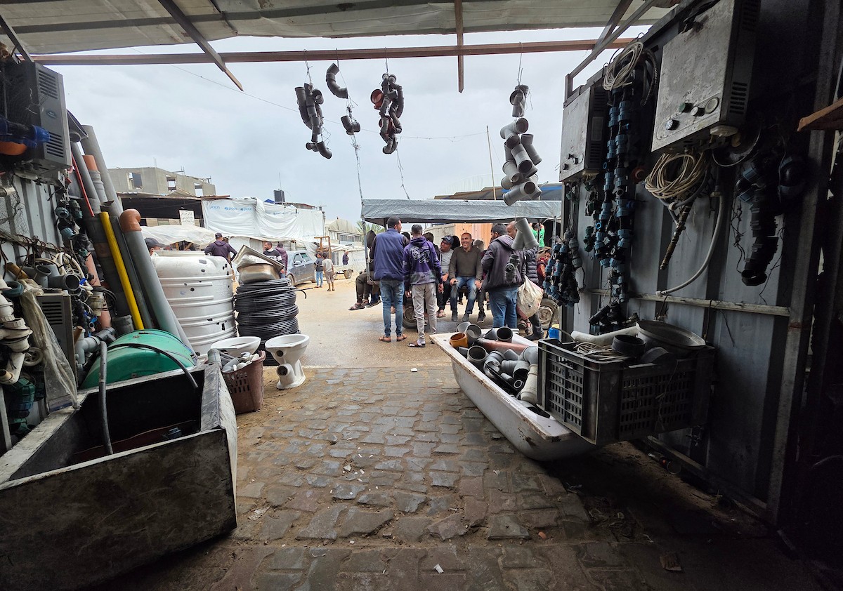 يبيع فلسطينيون موادًا مُستصلحة من أنقاض منازلهم المدمرة، بما في ذلك المعادن والخشب والأبواب ومستلزمات النظافة، في سوق للخردة بمنطقة المواصي في خان يونس جنوب قطاع غزة، في 27 أبريل/نيسان 2026 (صورة: طارق محمد)