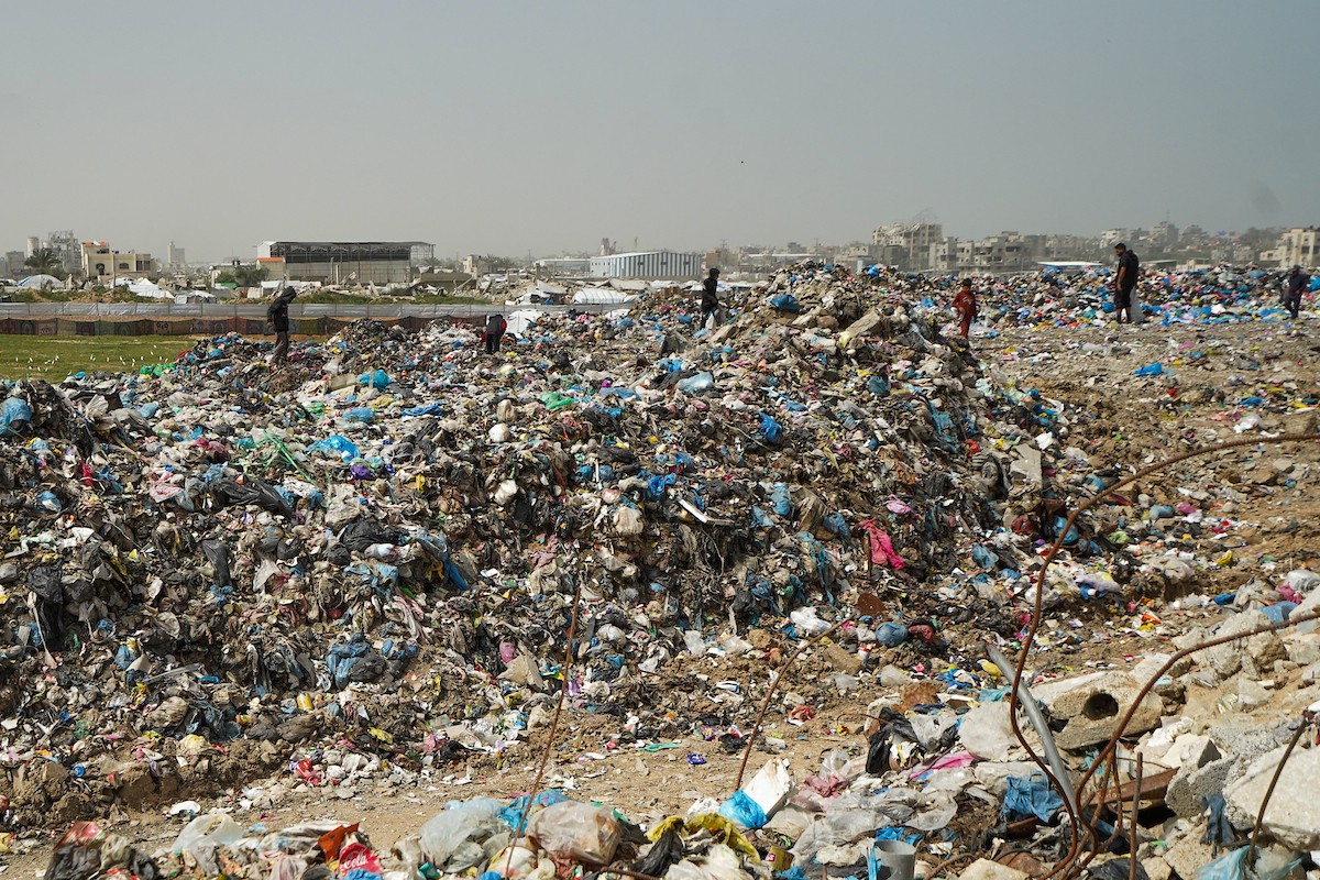 أطفال فلسطينيون يبحثون بين أكوام القمامة عن بقايا الطعام أو الألعاب في مكب نفايات بمخيم البريج للاجئين وسط قطاع غزة، في 4 أبريل/نيسان 2026، بالتزامن مع يوم الطفل الفلسطيني.(صورة: رمزي أبو عامر)