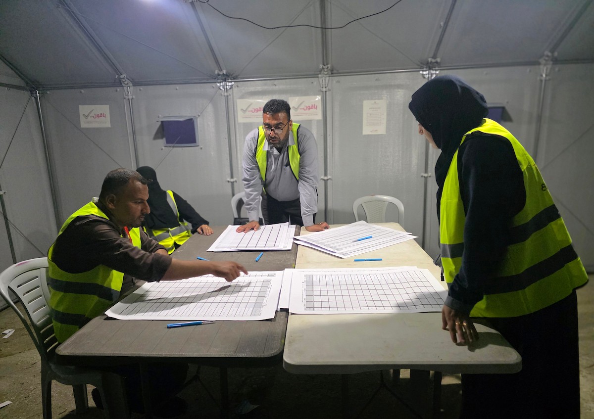 لجنة الانتخابات تُجري فرز قوائم المرشحين في الانتخابات المحلية الأولى في دير البلح وسط قطاع غزة منذ أكثر من عقدين، والأولى في الضفة الغربية منذ بدء حرب السابع من أكتوبر/ تشرين الأول 2023، 25 أبريل/نيسان 2026. (صورة: طارق محمد)