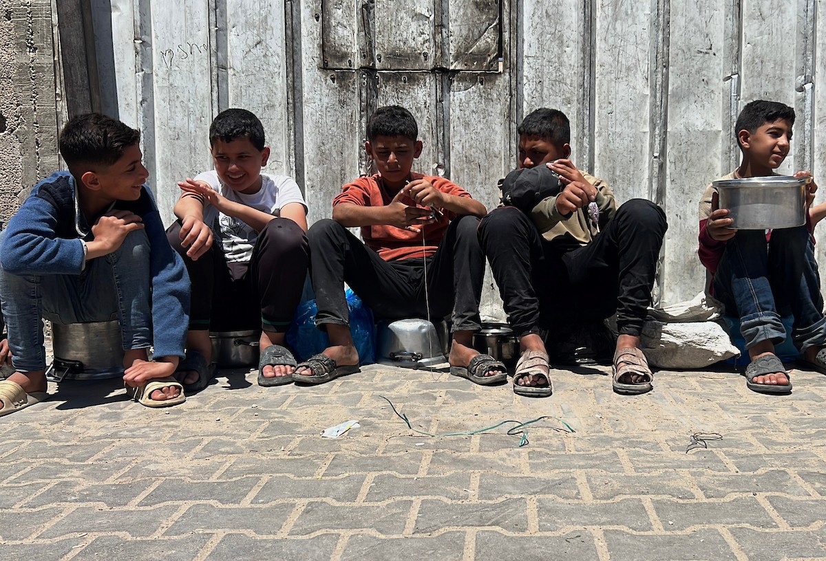 يتلقى فلسطينيون نازحون طعامًا من مطبخ خيري في مخيم النصيرات للاجئين وسط قطاع غزة، في 23 أبريل/نيسان 2026، (صورة: يوسف أبو وطفة)