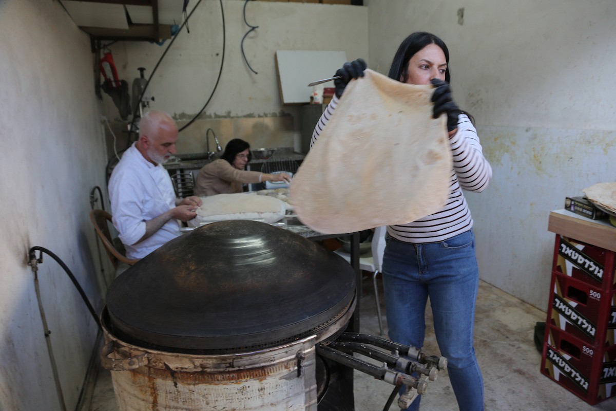 في 29 أبريل/نيسان 2026، عائلات سامرية تُعد خبز طري لطقوس ذبح الأضاحي في عيد الفصح على جبل جرزيم، المطل على مدينة نابلس في الضفة الغربية. ويعيش نحو 700 سامري بين مدينة نابلس في الضفة الغربية ومدينة حولون جنوب تل أبيب. (صورة: محمد ناصر)