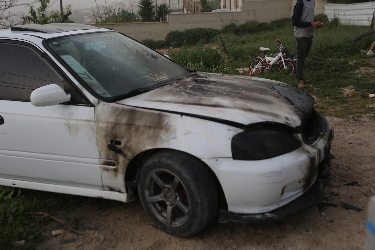 يقف فلسطينيون وسط آثار الدمار في قرية عورتا جنوب نابلس شمال الضفة الغربية، عقب هجوم نفذه مستوطنون إسرائيليون استهدف مركبات ومنازل المواطنين، مخلّفًا أضرارًا واسعة، وفق شهود عيان. 17 أبريل/نيسان 2026. تصوير: محمد ناصر.