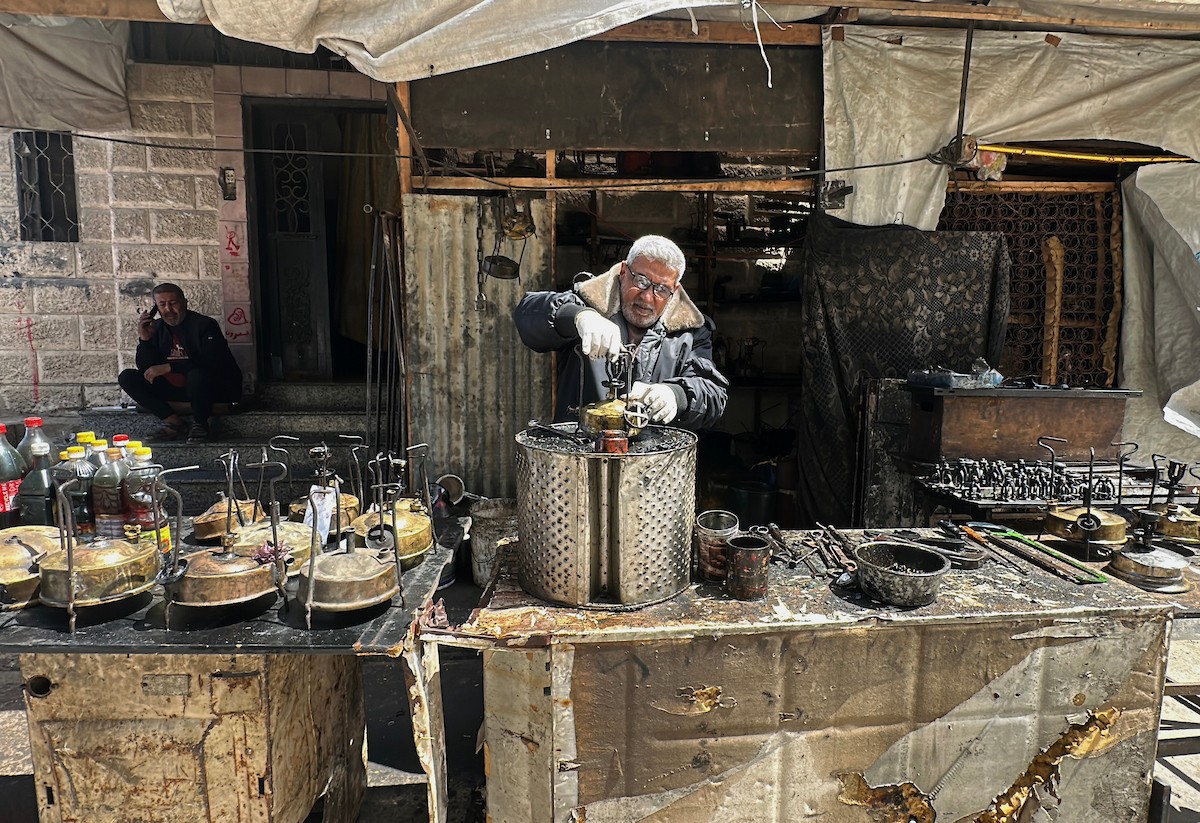 عادل عيسى، 63 عامًا، يُصلح مواقد الكيروسين القديمة في ورشته بمخيم الشاطئ، في مدينة غزة، صورة فوتوغرافية لهادي داود
