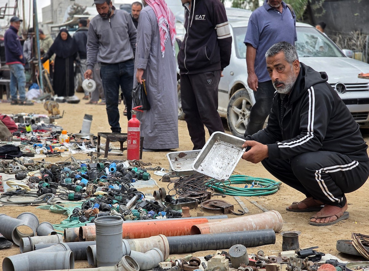 يبيع فلسطينيون موادًا مُستصلحة من أنقاض منازلهم المدمرة، بما في ذلك المعادن والخشب والأبواب ومستلزمات النظافة، في سوق للخردة بمنطقة المواصي في خان يونس جنوب قطاع غزة، في 27 أبريل/نيسان 2026 (صورة: طارق محمد)