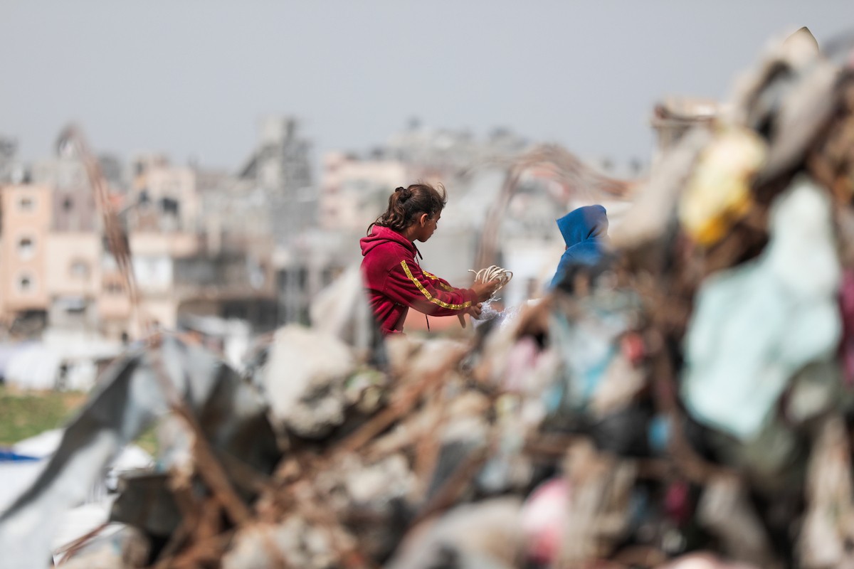 أطفال فلسطينيون يبحثون بين أكوام القمامة عن بقايا الطعام أو الألعاب في مكب نفايات بمخيم البريج للاجئين وسط قطاع غزة، في 4 أبريل/نيسان 2026، بالتزامن مع يوم الطفل الفلسطيني.(صورة: رمزي أبو عامر)