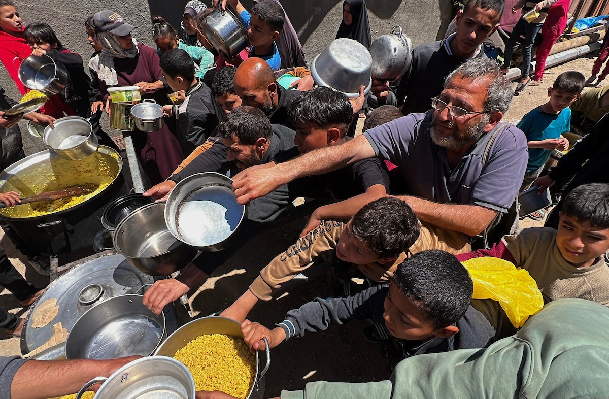 يتلقى فلسطينيون نازحون طعامًا من مطبخ خيري في مخيم النصيرات للاجئين وسط قطاع غزة، في 23 أبريل/نيسان 2026، (صورة: يوسف أبو وطفة)