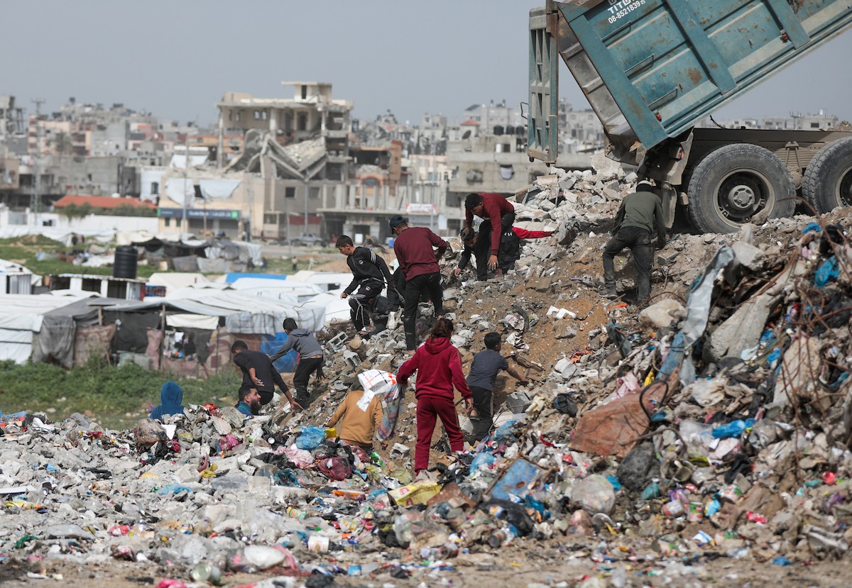 أطفال فلسطينيون يبحثون بين أكوام القمامة عن بقايا الطعام أو الألعاب في مكب نفايات بمخيم البريج للاجئين وسط قطاع غزة، في 4 أبريل/نيسان 2026، بالتزامن مع يوم الطفل الفلسطيني.(صورة: رمزي أبو عامر)