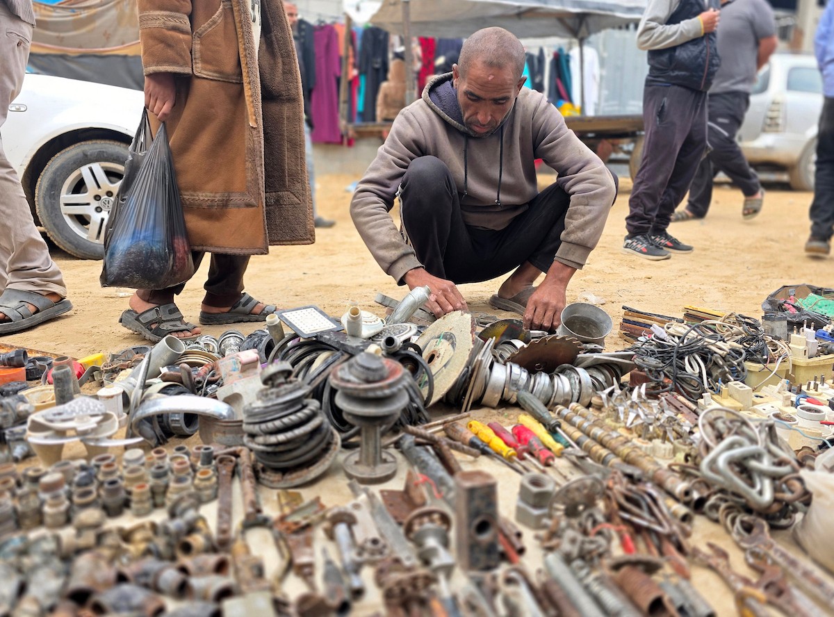 يبيع فلسطينيون موادًا مُستصلحة من أنقاض منازلهم المدمرة، بما في ذلك المعادن والخشب والأبواب ومستلزمات النظافة، في سوق للخردة بمنطقة المواصي في خان يونس جنوب قطاع غزة، في 27 أبريل/نيسان 2026 (صورة: طارق محمد)