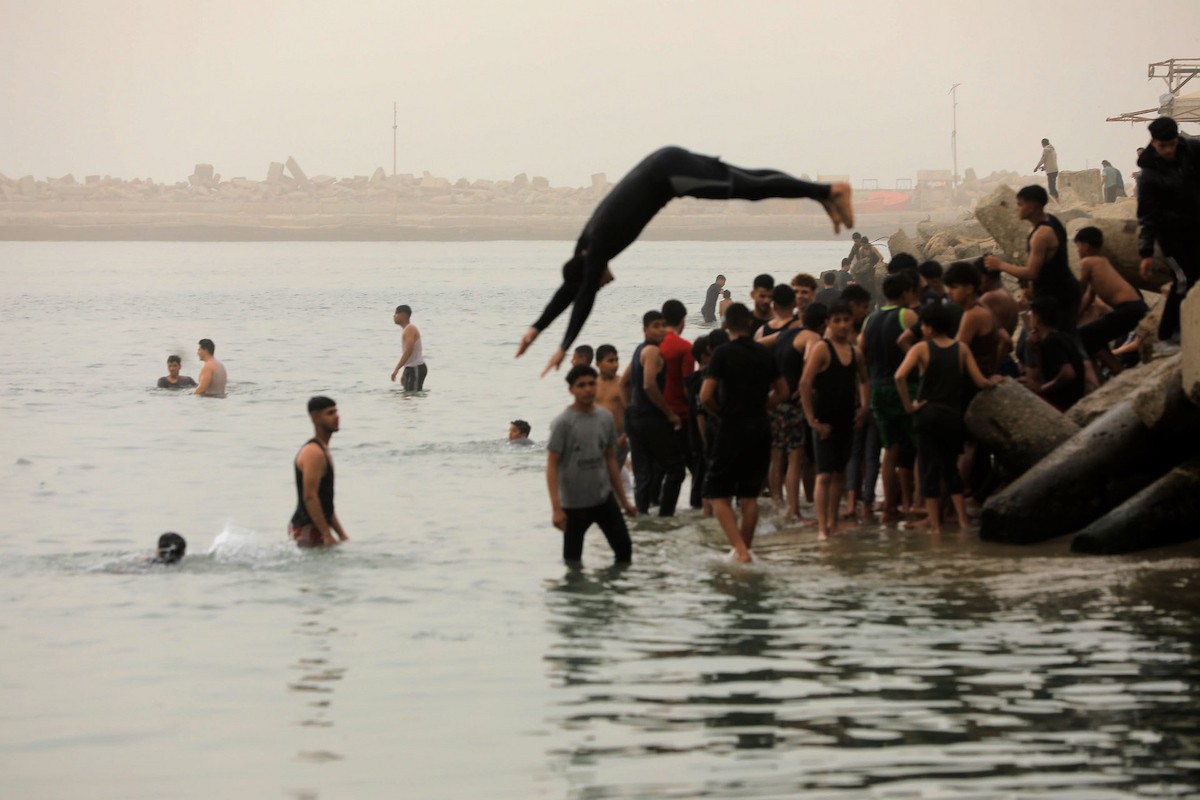 يقضي أطفال فلسطينيون أوقاتهم على شاطئ  غزة، باحثين عن ملاذ من حرارة الشمس وضغوط الحياة اليومية، في ظلّ الظروف الإنسانية المتردية التي يواجهها سكان القطاع جراء الحرب الدائرة، 17 أبريل/نيسان 2026. تصوير: بلال أسامة