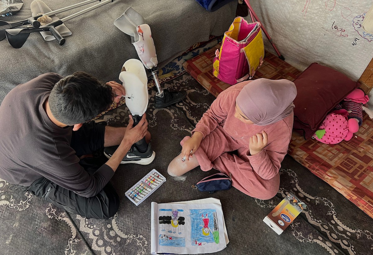 منة وائل عاشور (12 عاماً) وشقيقها فايز (24 عاماً) يعيشان في خيمة نزوح بمدينة دير البلح وسط قطاع غزة، بعد أن فقدا أطرافهما جراء هجوم إسرائيلي قبل نحو تسعة أشهر، 16 أبريل/نيسان 2026. صورة: يوسف أبو طفة