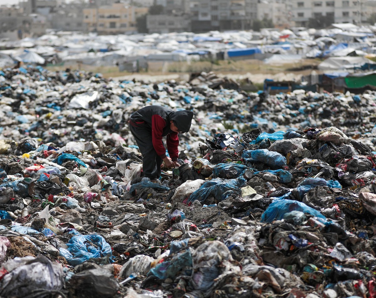 أطفال فلسطينيون يبحثون بين أكوام القمامة عن بقايا الطعام أو الألعاب في مكب نفايات بمخيم البريج للاجئين وسط قطاع غزة، في 4 أبريل/نيسان 2026، بالتزامن مع يوم الطفل الفلسطيني.(صورة: رمزي أبو عامر)