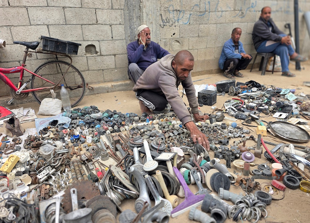يبيع فلسطينيون موادًا مُستصلحة من أنقاض منازلهم المدمرة، بما في ذلك المعادن والخشب والأبواب ومستلزمات النظافة، في سوق للخردة بمنطقة المواصي في خان يونس جنوب قطاع غزة، في 27 أبريل/نيسان 2026 (صورة: طارق محمد)