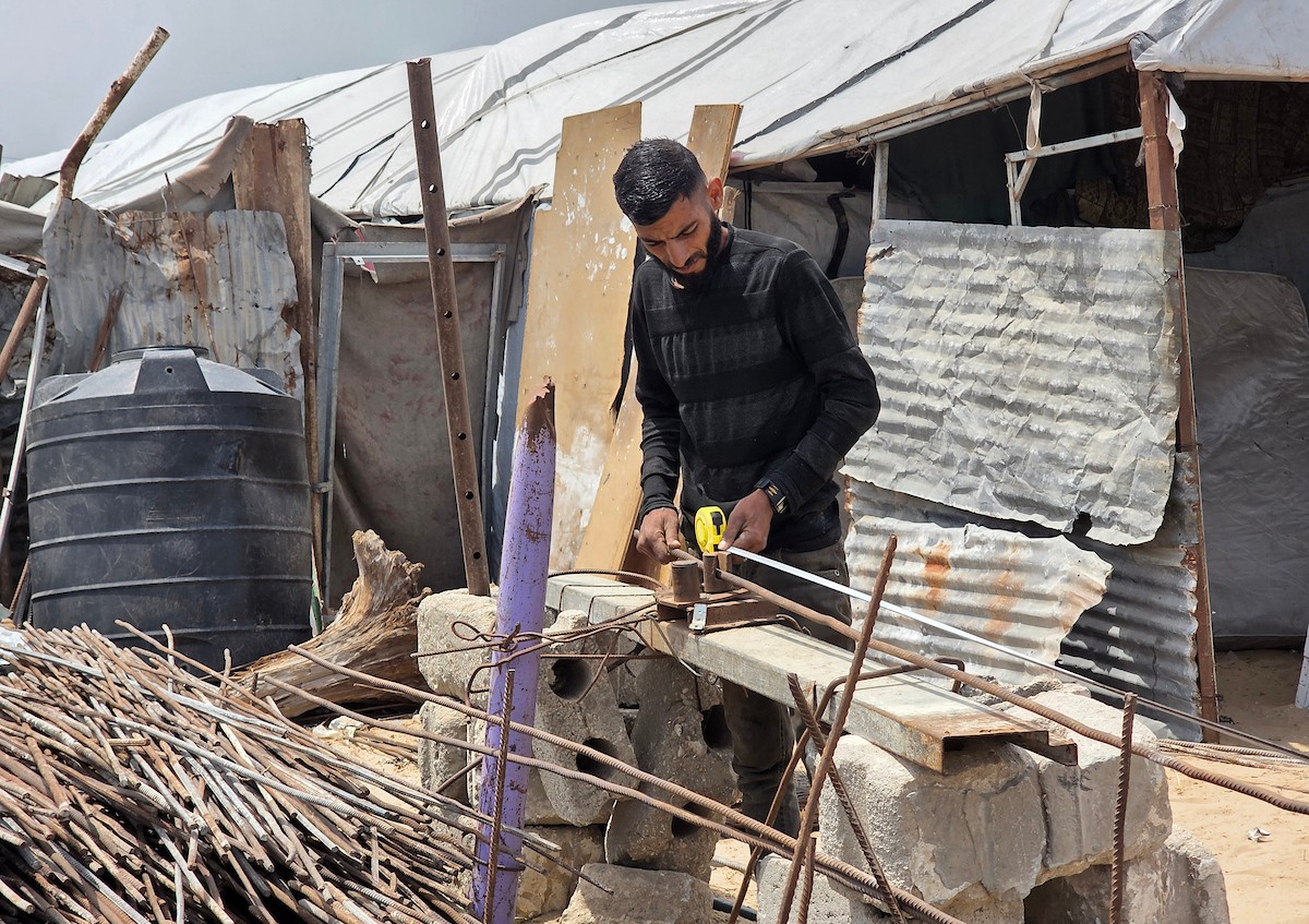 يبيع فلسطينيون موادًا مُستصلحة من أنقاض منازلهم المدمرة، بما في ذلك المعادن والخشب والأبواب ومستلزمات النظافة، في سوق للخردة بمنطقة المواصي في خان يونس جنوب قطاع غزة، في 27 أبريل/نيسان 2026 (صورة: طارق محمد)