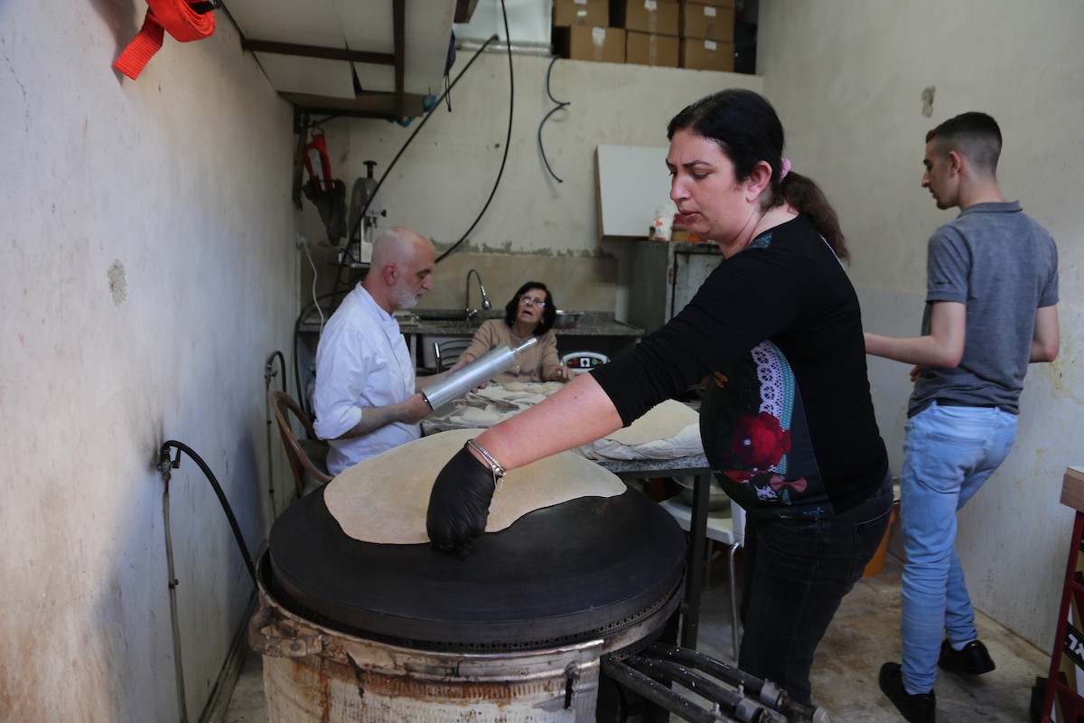 في 29 أبريل/نيسان 2026، عائلات سامرية تُعد خبز طري لطقوس ذبح الأضاحي في عيد الفصح على جبل جرزيم، المطل على مدينة نابلس في الضفة الغربية. ويعيش نحو 700 سامري بين مدينة نابلس في الضفة الغربية ومدينة حولون جنوب تل أبيب. (صورة: محمد ناصر)