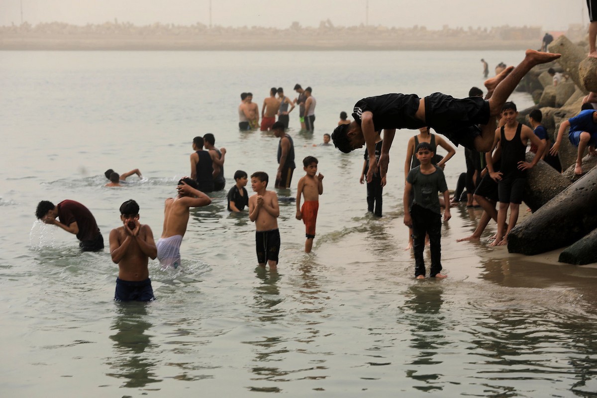 يقضي أطفال فلسطينيون أوقاتهم على شاطئ  غزة، باحثين عن ملاذ من حرارة الشمس وضغوط الحياة اليومية، في ظلّ الظروف الإنسانية المتردية التي يواجهها سكان القطاع جراء الحرب الدائرة، 17 أبريل/نيسان 2026. تصوير: بلال أسامة