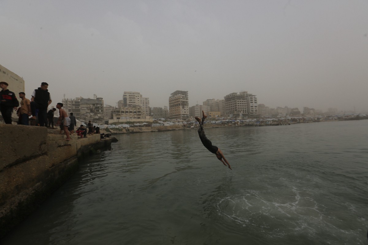 يقضي أطفال فلسطينيون أوقاتهم على شاطئ  غزة، باحثين عن ملاذ من حرارة الشمس وضغوط الحياة اليومية، في ظلّ الظروف الإنسانية المتردية التي يواجهها سكان القطاع جراء الحرب الدائرة، 17 أبريل/نيسان 2026. تصوير: بلال أسامة
