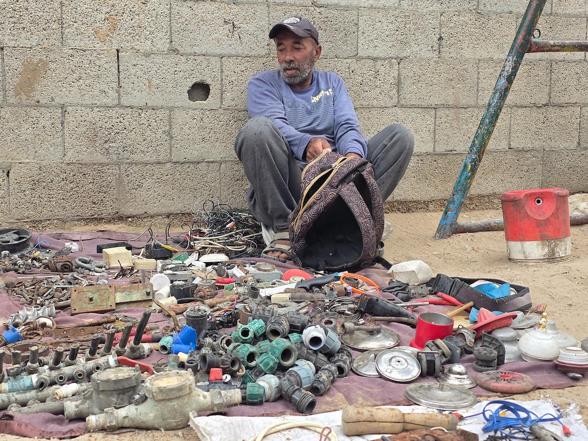 يبيع فلسطينيون موادًا مُستصلحة من أنقاض منازلهم المدمرة، بما في ذلك المعادن والخشب والأبواب ومستلزمات النظافة، في سوق للخردة بمنطقة المواصي في خان يونس جنوب قطاع غزة، في 27 أبريل/نيسان 2026 (صورة: طارق محمد)