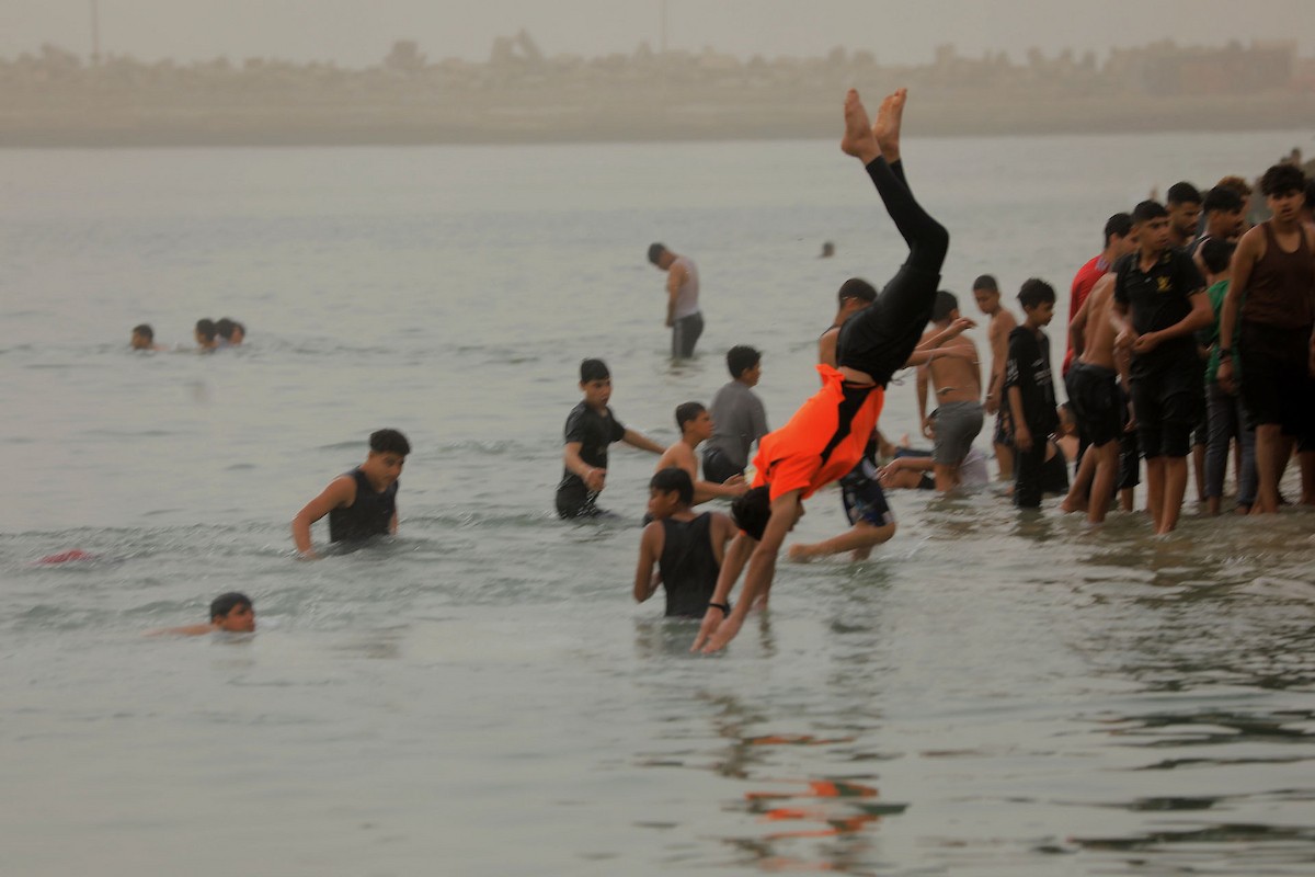 يقضي أطفال فلسطينيون أوقاتهم على شاطئ  غزة، باحثين عن ملاذ من حرارة الشمس وضغوط الحياة اليومية، في ظلّ الظروف الإنسانية المتردية التي يواجهها سكان القطاع جراء الحرب الدائرة، 17 أبريل/نيسان 2026. تصوير: بلال أسامة