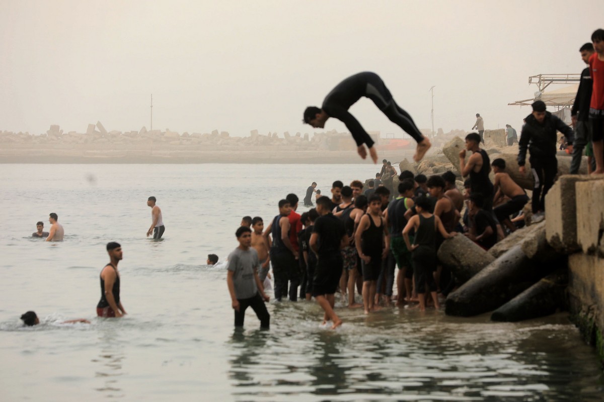 يقضي أطفال فلسطينيون أوقاتهم على شاطئ  غزة، باحثين عن ملاذ من حرارة الشمس وضغوط الحياة اليومية، في ظلّ الظروف الإنسانية المتردية التي يواجهها سكان القطاع جراء الحرب الدائرة، 17 أبريل/نيسان 2026. تصوير: بلال أسامة