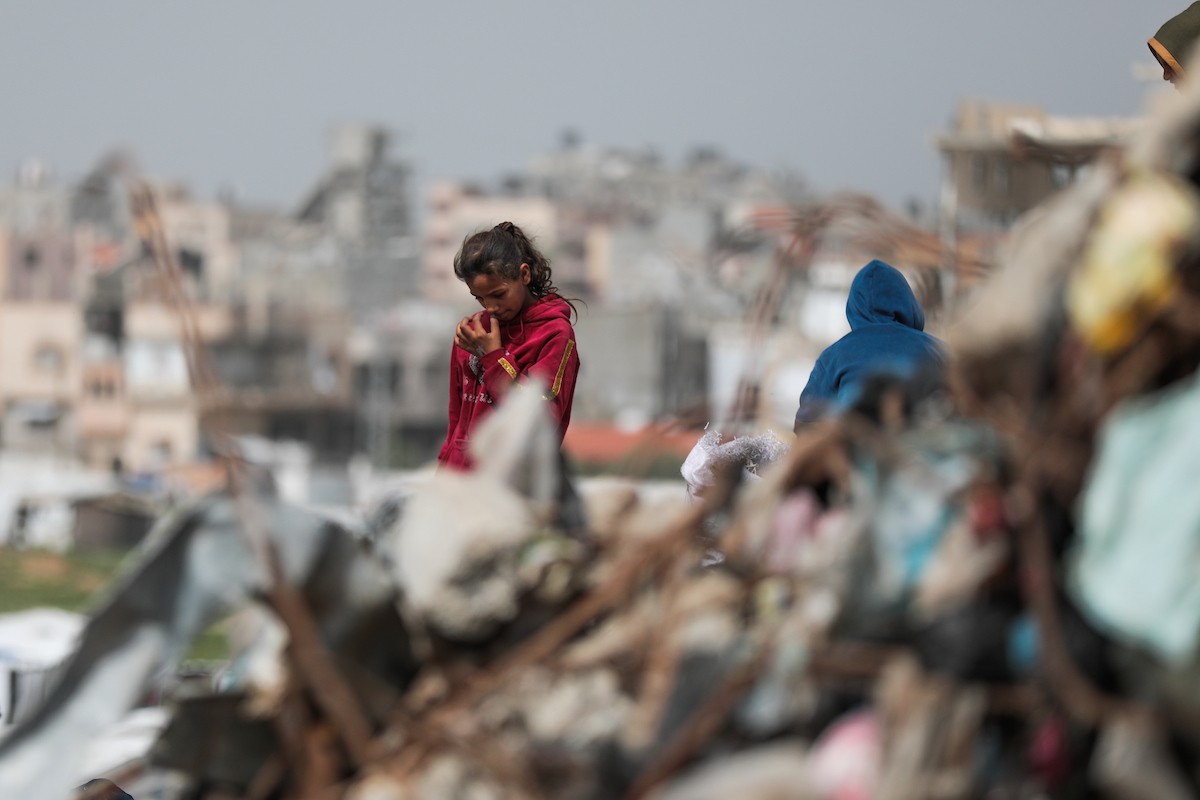 أطفال فلسطينيون يبحثون بين أكوام القمامة عن بقايا الطعام أو الألعاب في مكب نفايات بمخيم البريج للاجئين وسط قطاع غزة، في 4 أبريل/نيسان 2026، بالتزامن مع يوم الطفل الفلسطيني.(صورة: رمزي أبو عامر)