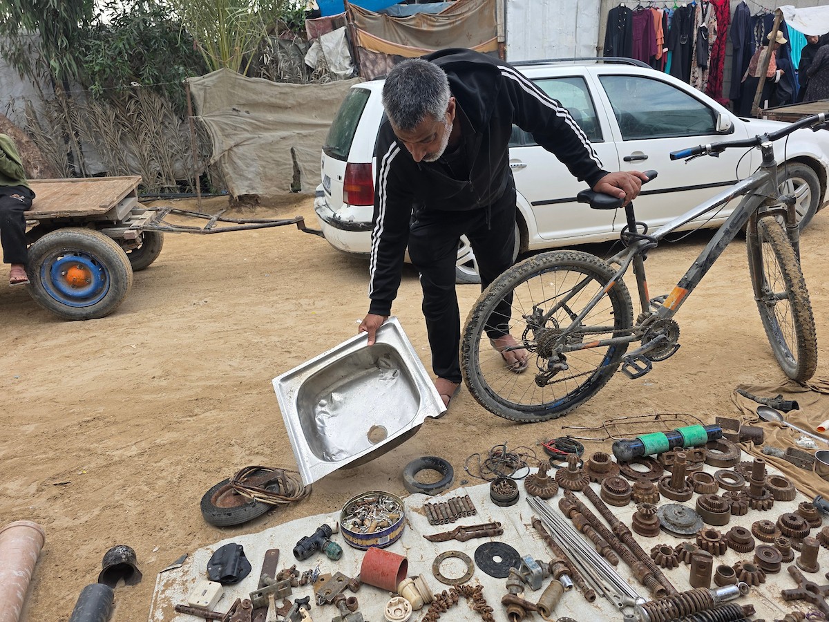 يبيع فلسطينيون موادًا مُستصلحة من أنقاض منازلهم المدمرة، بما في ذلك المعادن والخشب والأبواب ومستلزمات النظافة، في سوق للخردة بمنطقة المواصي في خان يونس جنوب قطاع غزة، في 27 أبريل/نيسان 2026 (صورة: طارق محمد)
