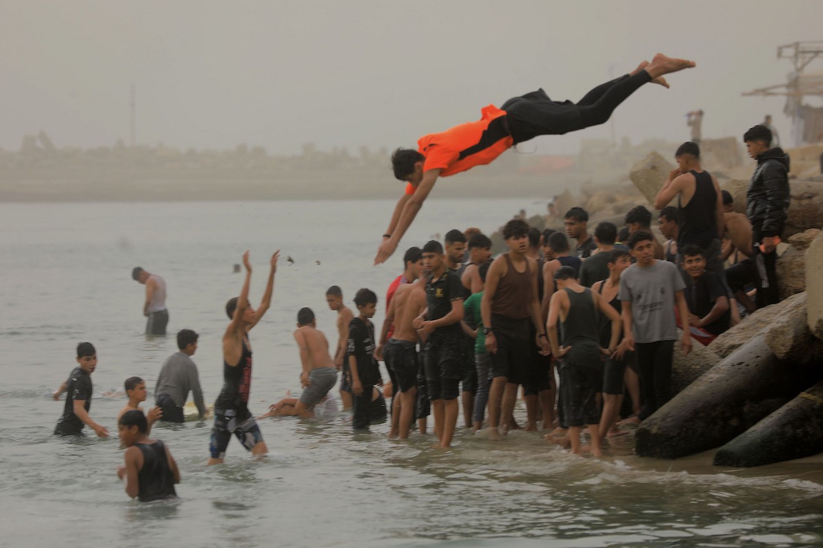 يقضي أطفال فلسطينيون أوقاتهم على شاطئ  غزة، باحثين عن ملاذ من حرارة الشمس وضغوط الحياة اليومية، في ظلّ الظروف الإنسانية المتردية التي يواجهها سكان القطاع جراء الحرب الدائرة، 17 أبريل/نيسان 2026. تصوير: بلال أسامة