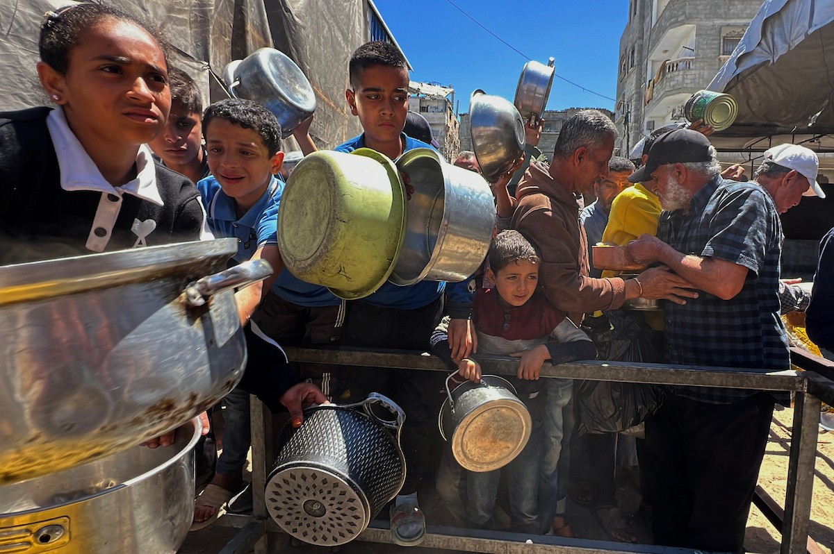 يتلقى فلسطينيون نازحون طعامًا من مطبخ خيري في مخيم النصيرات للاجئين وسط قطاع غزة، في 23 أبريل/نيسان 2026، (صورة: يوسف أبو وطفة)