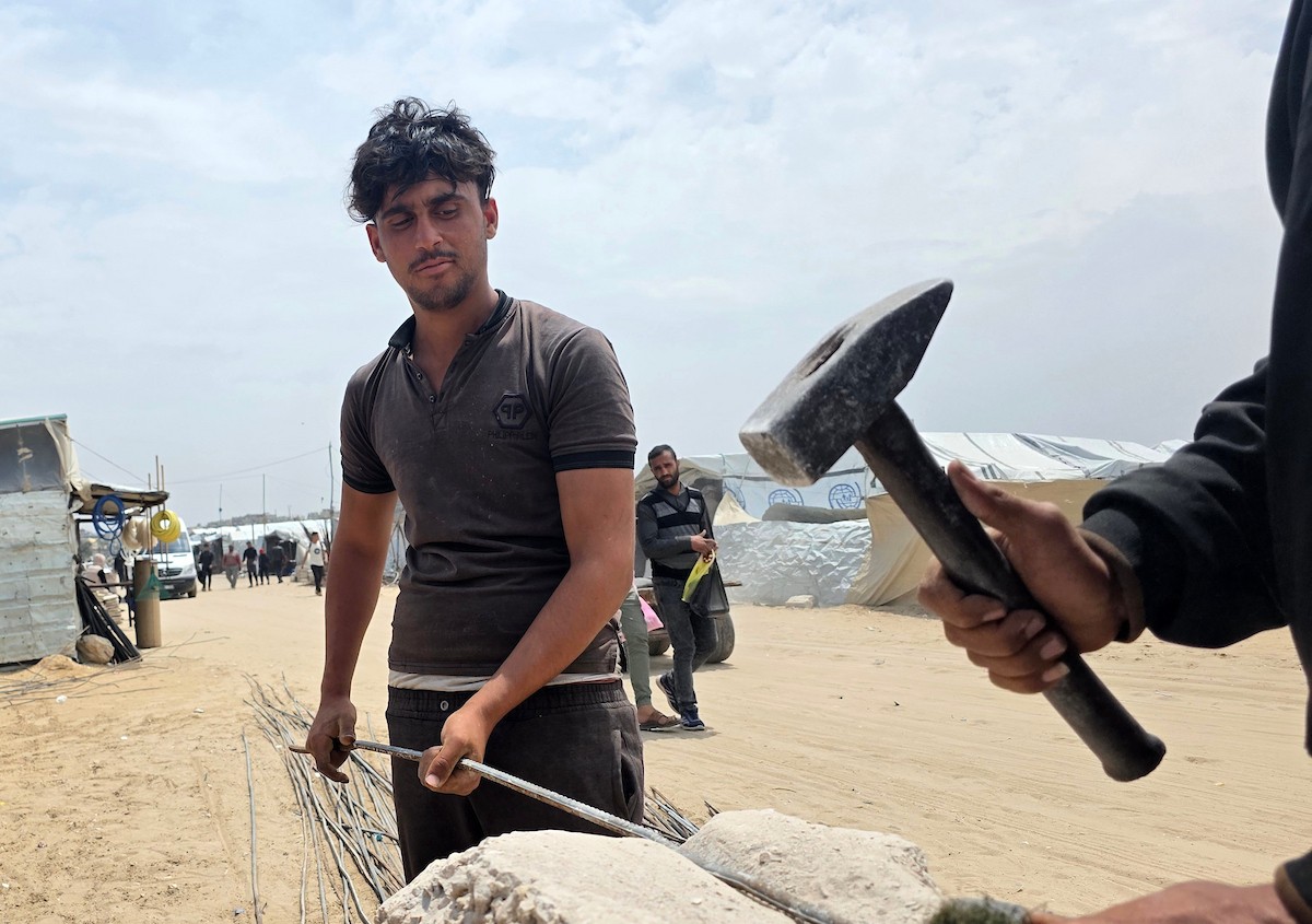 يبيع فلسطينيون موادًا مُستصلحة من أنقاض منازلهم المدمرة، بما في ذلك المعادن والخشب والأبواب ومستلزمات النظافة، في سوق للخردة بمنطقة المواصي في خان يونس جنوب قطاع غزة، في 27 أبريل/نيسان 2026 (صورة: طارق محمد)