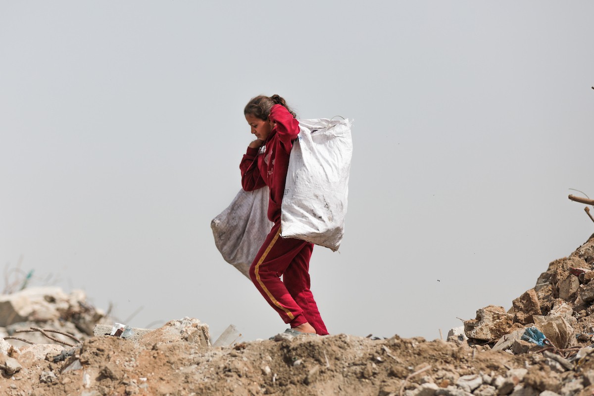 أطفال فلسطينيون يبحثون بين أكوام القمامة عن بقايا الطعام أو الألعاب في مكب نفايات بمخيم البريج للاجئين وسط قطاع غزة، في 4 أبريل/نيسان 2026، بالتزامن مع يوم الطفل الفلسطيني.(صورة: رمزي أبو عامر)