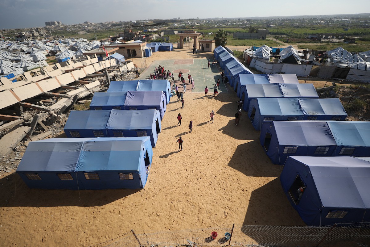 يتلقى طلاب فلسطينيون نازحون تعليمهم داخل خيام مؤقتة نُصبت قرب مدرسة دمرها قصف جوي إسرائيلي خلال الحرب، في مخيم النصيرات وسط قطاع غزة، بتاريخ 31 مارس/آذار 2026.  صورة: حسن الجديدي