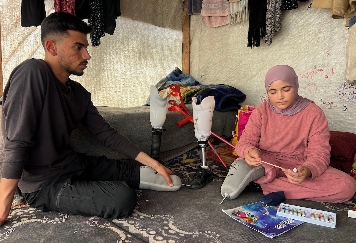 منة وائل عاشور (12 عاماً) وشقيقها فايز (24 عاماً) يعيشان في خيمة نزوح بمدينة دير البلح وسط قطاع غزة، بعد أن فقدا أطرافهما جراء هجوم إسرائيلي قبل نحو تسعة أشهر، 16 أبريل/نيسان 2026. صورة: يوسف أبو طفة