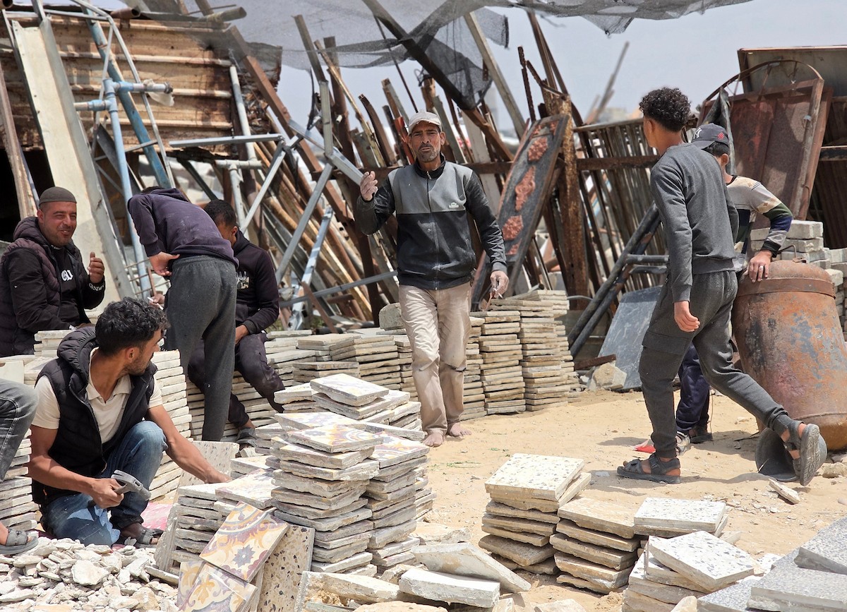 يبيع فلسطينيون موادًا مُستصلحة من أنقاض منازلهم المدمرة، بما في ذلك المعادن والخشب والأبواب ومستلزمات النظافة، في سوق للخردة بمنطقة المواصي في خان يونس جنوب قطاع غزة، في 27 أبريل/نيسان 2026 (صورة: طارق محمد)