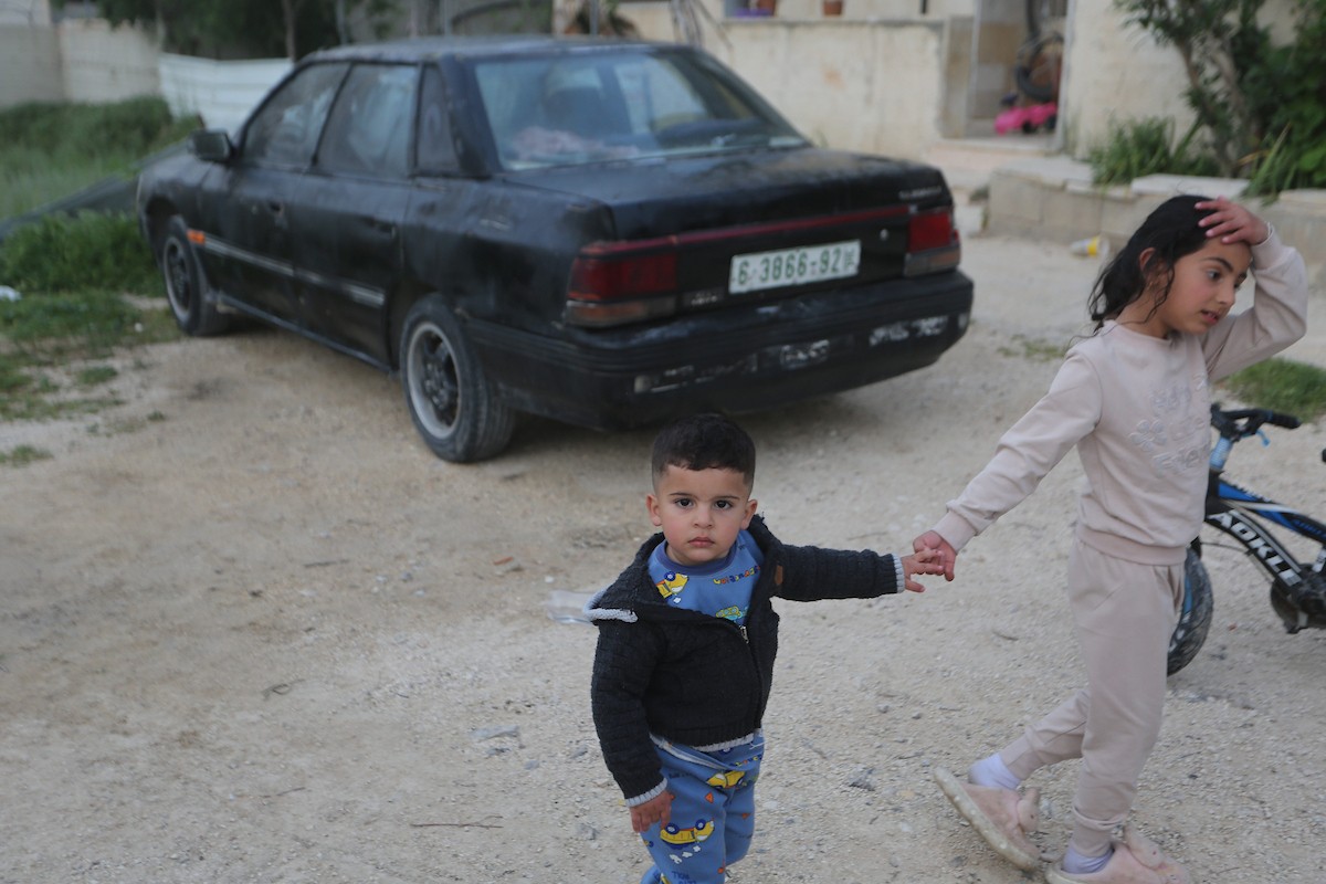يقف فلسطينيون وسط آثار الدمار في قرية عورتا جنوب نابلس شمال الضفة الغربية، عقب هجوم نفذه مستوطنون إسرائيليون استهدف مركبات ومنازل المواطنين، مخلّفًا أضرارًا واسعة، وفق شهود عيان. 17 أبريل/نيسان 2026. تصوير: محمد ناصر.