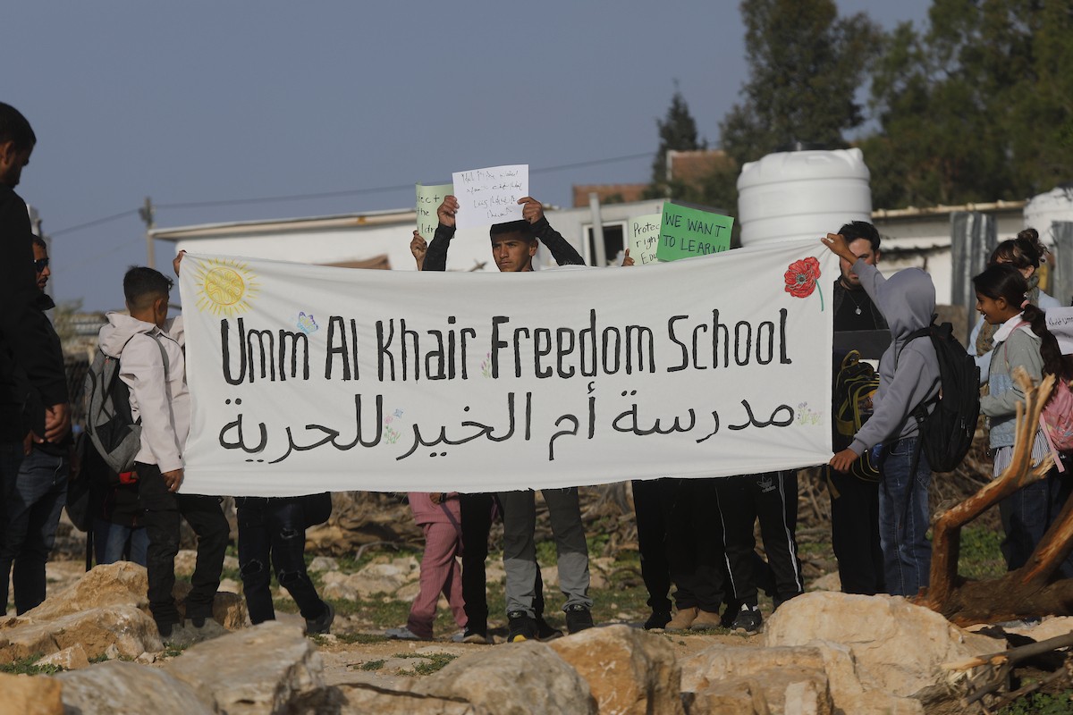 الخليل - أطفال خربة أم الخير وبمشاركة نشطاء سلام دوليين ينظمون وقفة سلمية احتجاجا على إغلاق الجيش الإسرائيلي للطريق الرئيسي المؤدي إلى مدارسهم منذ أسبوع، 19 أبريل/نيسان 2026. تصوير: مأمون وزواز