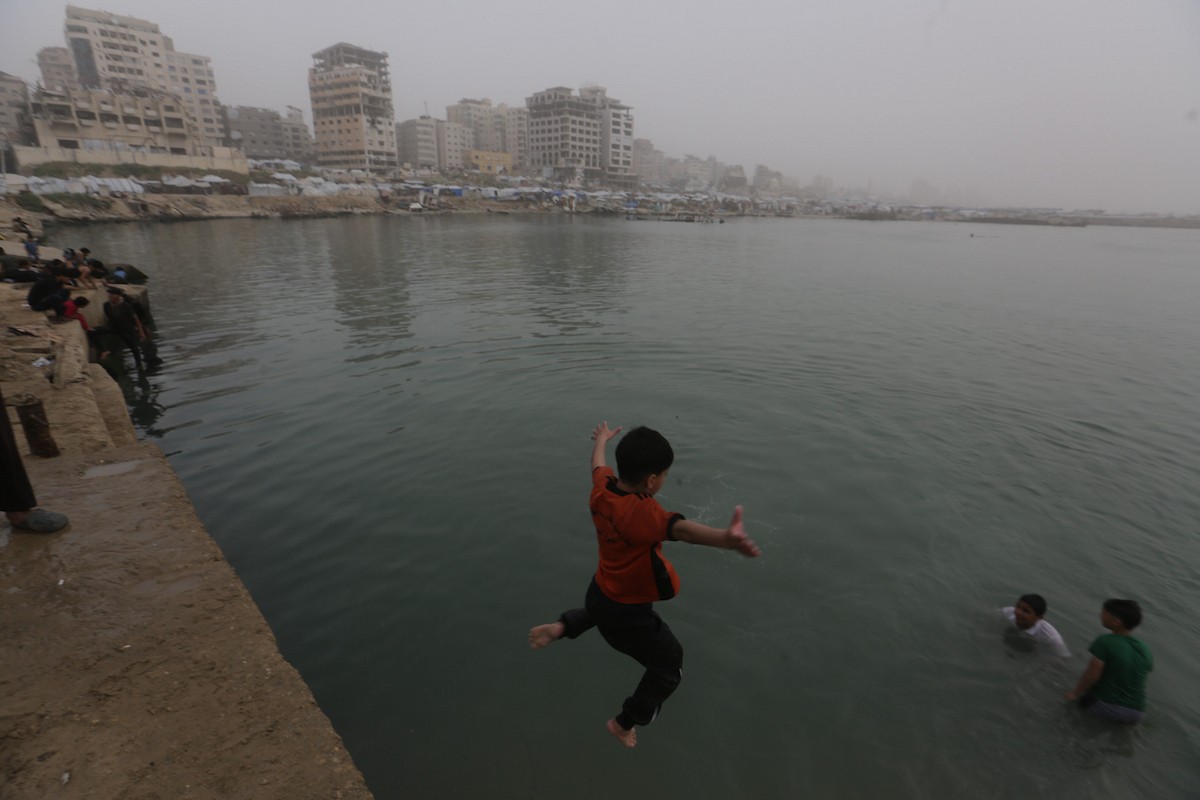 يقضي أطفال فلسطينيون أوقاتهم على شاطئ  غزة، باحثين عن ملاذ من حرارة الشمس وضغوط الحياة اليومية، في ظلّ الظروف الإنسانية المتردية التي يواجهها سكان القطاع جراء الحرب الدائرة، 17 أبريل/نيسان 2026. تصوير: بلال أسامة