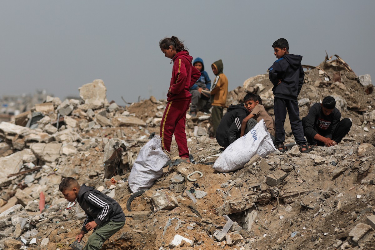 أطفال فلسطينيون يبحثون بين أكوام القمامة عن بقايا الطعام أو الألعاب في مكب نفايات بمخيم البريج للاجئين وسط قطاع غزة، في 4 أبريل/نيسان 2026، بالتزامن مع يوم الطفل الفلسطيني.(صورة: رمزي أبو عامر)