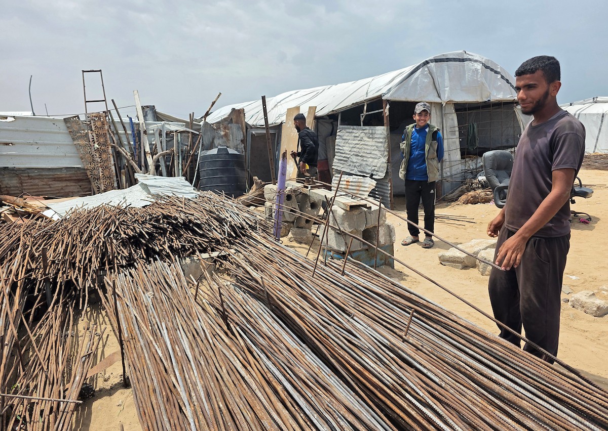 يبيع فلسطينيون موادًا مُستصلحة من أنقاض منازلهم المدمرة، بما في ذلك المعادن والخشب والأبواب ومستلزمات النظافة، في سوق للخردة بمنطقة المواصي في خان يونس جنوب قطاع غزة، في 27 أبريل/نيسان 2026 (صورة: طارق محمد)