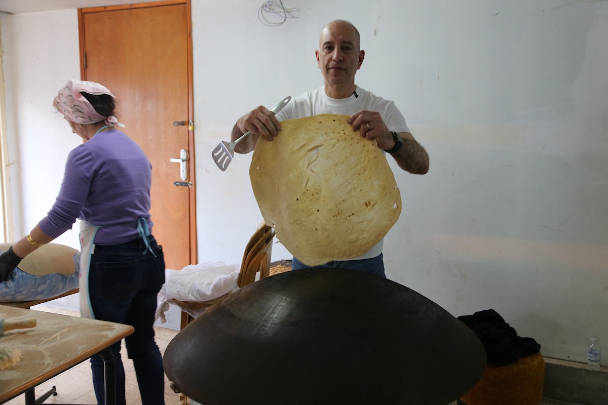 في 29 أبريل/نيسان 2026، عائلات سامرية تُعد خبز طري لطقوس ذبح الأضاحي في عيد الفصح على جبل جرزيم، المطل على مدينة نابلس في الضفة الغربية. ويعيش نحو 700 سامري بين مدينة نابلس في الضفة الغربية ومدينة حولون جنوب تل أبيب. (صورة: محمد ناصر)