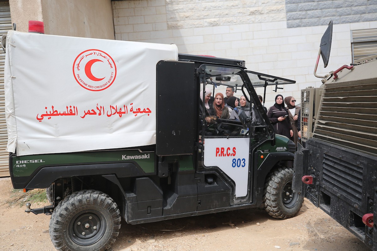 عائلات فلسطينية تنتظر عند نقطة تفتيش تابعة للجيش الإسرائيلي عند مدخل مخيم جنين للاجئين، قرب مدينة جنين في الضفة الغربية، لاستعادة ممتلكاتها من منازلها، 13 أبريل/نيسان 2026. صورة: محمد ناصر